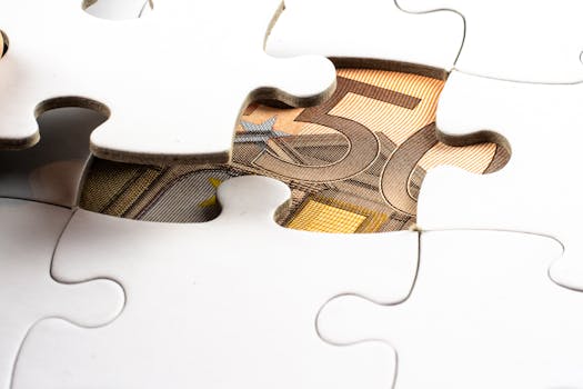 Close-up of a partially completed puzzle revealing a Euro note underneath, symbolizing financial discovery.