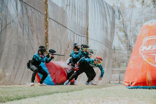 Exciting outdoor paintball game with players in action wearing gear and masks.