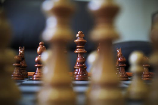 Intriguing close-up view of chess pieces in strategic battle on a wooden chessboard.